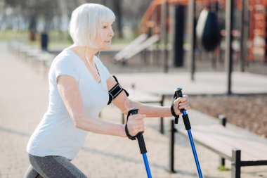 Mutlu kadın egzersiz yaparken koltuk değneği kullanarak