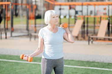 Neşeli kadın el ağırlıkları ile egzersiz