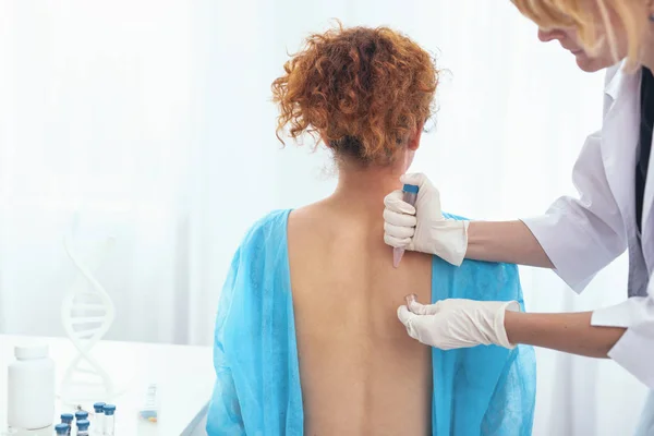 Jovem mulher com a pele examinada por um médico — Fotografia de Stock