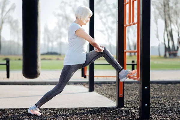 Determined aged woman training outdoors — Stock Photo, Image