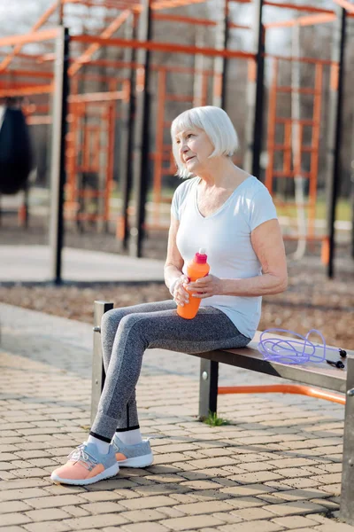 Счастливая женщина отдыхает на скамейке — стоковое фото