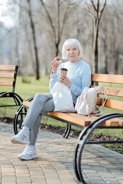 Poważne kobieta korzystających z jej kawę i ciasteczka — Zdjęcie stockowe