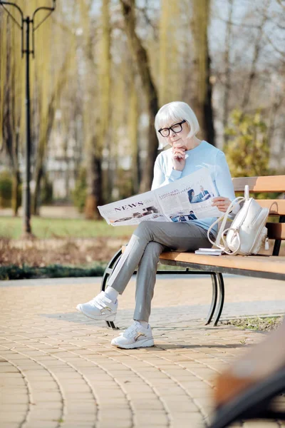 Ernsthafte alte Frau beim Zeitungslesen — Stockfoto