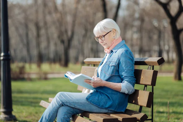 Velha mulher determinada lendo um livro — Fotografia de Stock