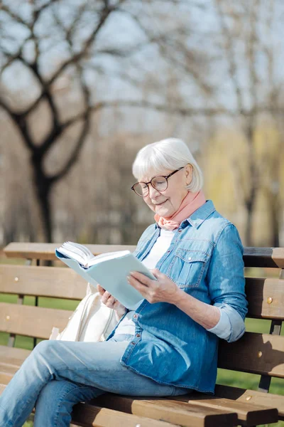 Glad gammal kvinna läser en bok — Stockfoto