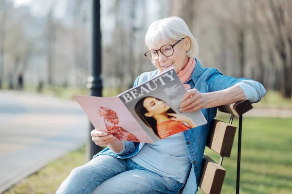 Sprudlande år kvinna läser en tidskrift — Stockfoto