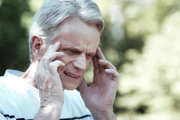 Hombre serio que tiene dolor de cabeza duro — Foto de Stock