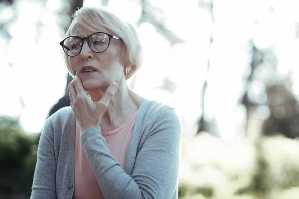 Upprörd kvinna röra hennes kind — Stockfoto