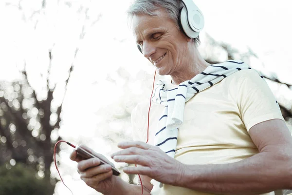 Happy mature man holding telephone in right hand — Stock Photo, Image