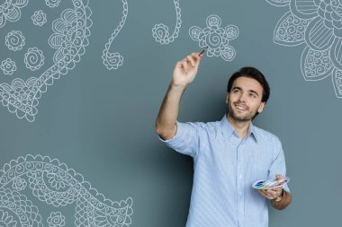 Yetenekli ressam bir çiçek çizerken gülümseyen