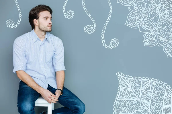 Serious man sitting on a chair and waiting for his doctor — Stock Photo, Image