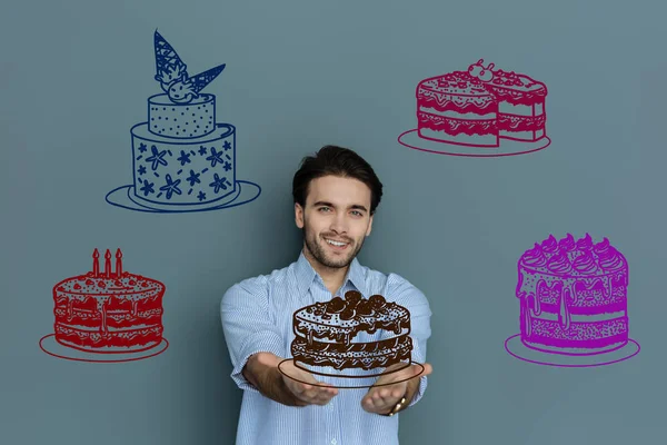 Cukiernik uśmiechający się wyglądający zadowolony pokazując jego nowe ciasta — Zdjęcie stockowe