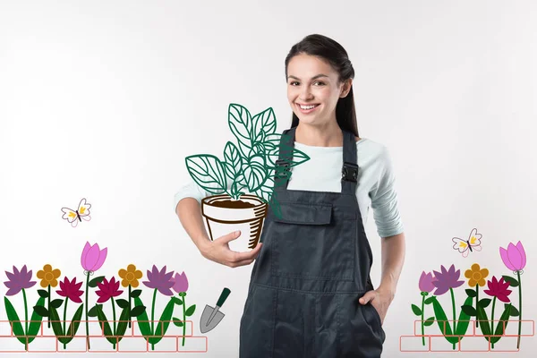 Jardinero positivo mirando alegre mientras que sostiene una planta grande — Foto de Stock