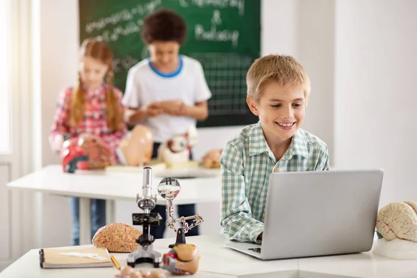 Glücklicher kleiner Junge schaut auf den Laptop-Bildschirm — Stockfoto