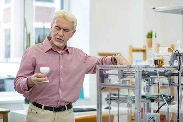 Handsome senior man scrutinizing model made with 3D printer — Stock Photo, Image