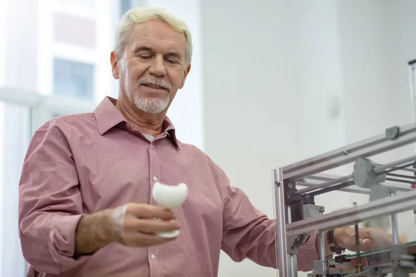 Homem sênior otimista verificando um modelo criado com impressora 3D — Fotografia de Stock