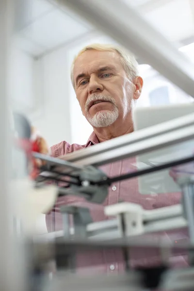 Красивый пожилой человек наблюдает за процессом печати — стоковое фото
