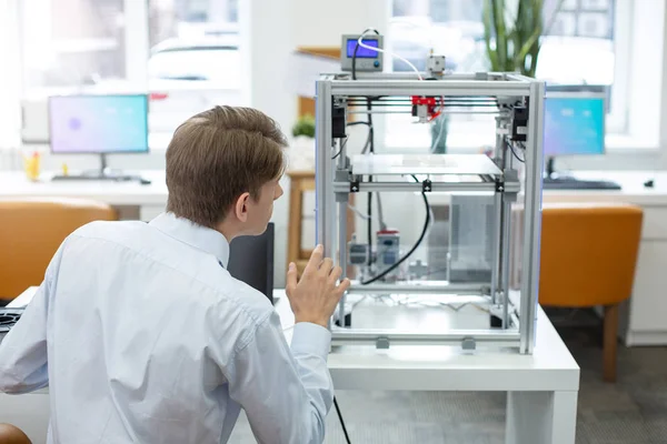 Trabajador de oficina guapo mirando a la impresora 3D — Foto de Stock