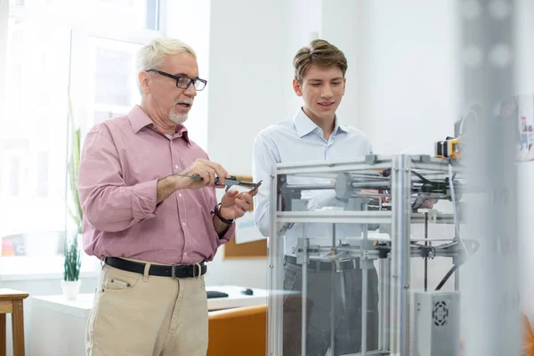 Ingeniero senior usando pinza mientras imprime modelos con pasante —  Fotos de Stock