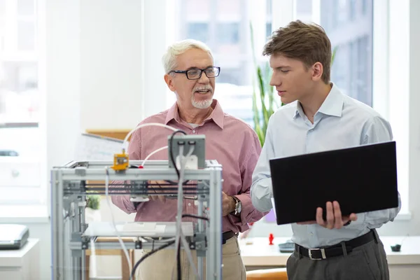 Senior engineer teaching how to change 3D printer configurations