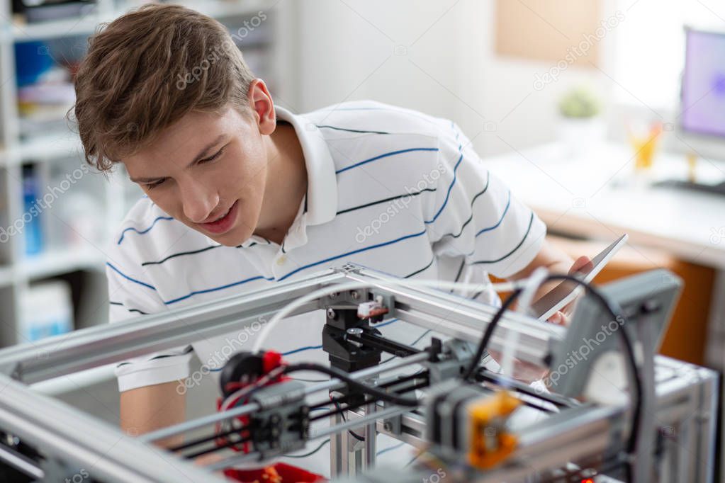 Upbeat young engineer printing 3D bell pepper