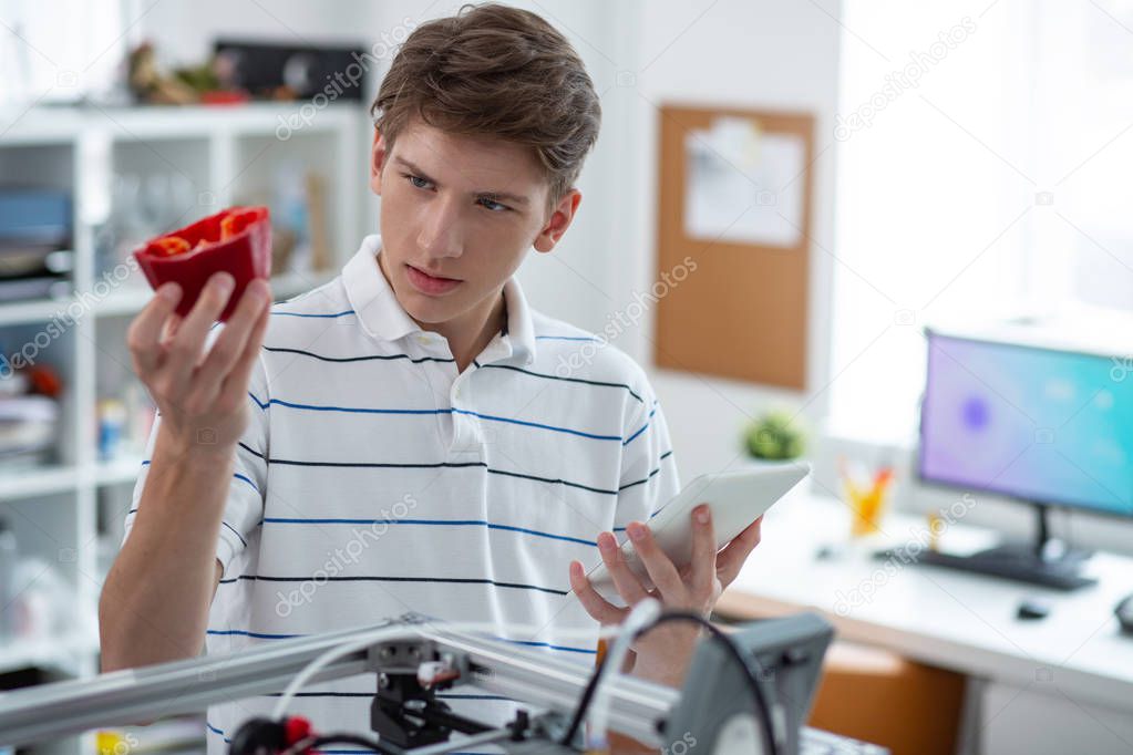 Charming young engineer examining bell pepper model