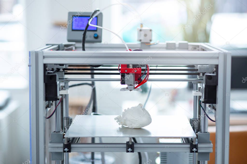 Modern 3D printer creating model of heart