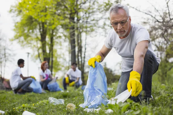 Atractivo voluntario senior recogiendo basura — Foto de Stock