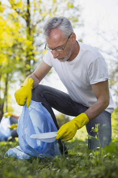 Voluntario maduro concentrado que encuentra el proyecto ecológico — Foto de Stock
