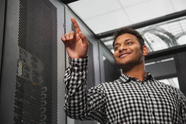 Técnico de TI alegre recontando armário do servidor — Fotografia de Stock