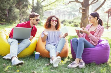 Çalışma süreci. Açık havada oturma ve projede çalışan neşeli iddialı iş arkadaşları