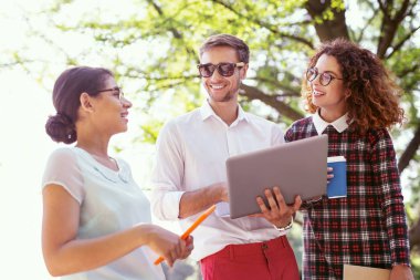 Diz üstü holding neşeli erkek öğrenci