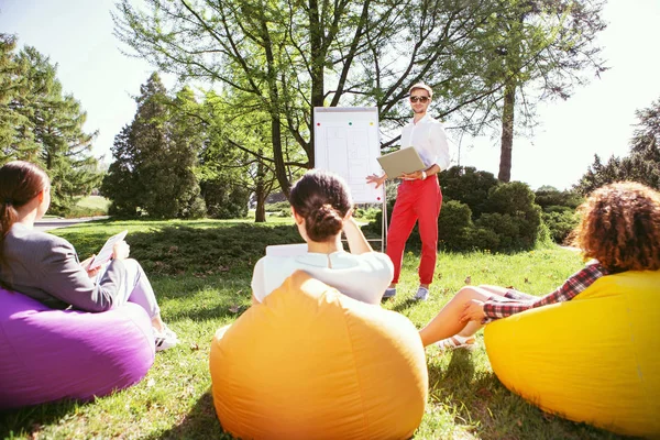 Zufriedener Mann im Gespräch mit Freunden über das Projekt — Stockfoto