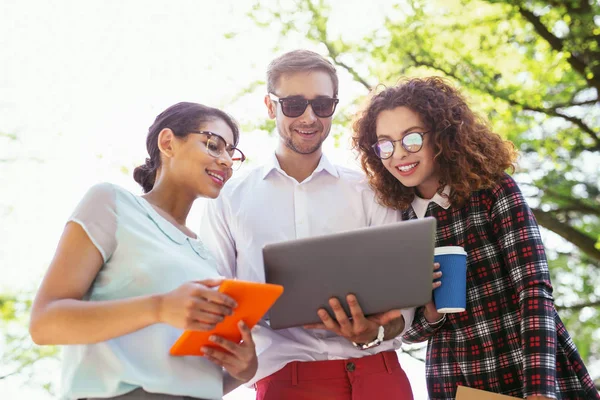 Estudante feliz masculino segurando seu laptop — Fotografia de Stock