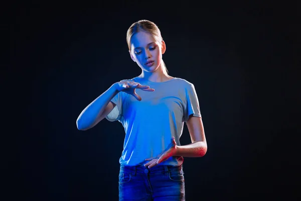 Smart young woman holding a virtual object — Stock Photo, Image