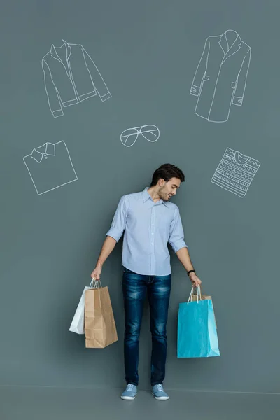 Uomo emotivo guardando i sacchetti di carta mentre andare a fare shopping — Foto Stock