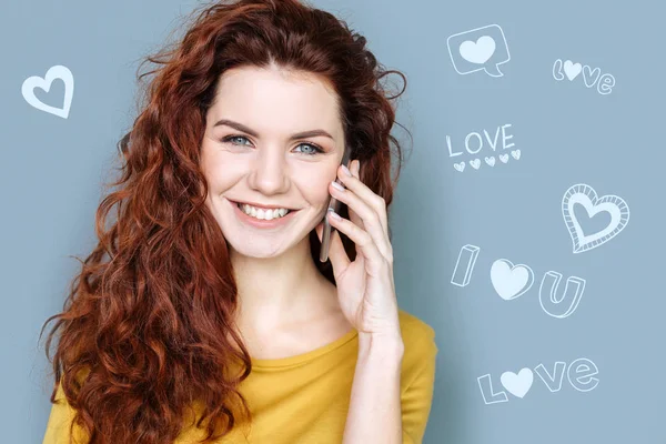 Jovem mulher sorrindo e falando ao telefone com seu namorado — Fotografia de Stock