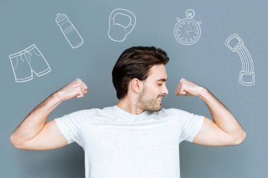 Kaslarına gösterilen ve memnun seyir neşeli sporcu