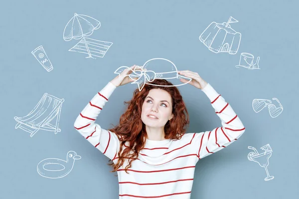 Beautiful woman trying on a nice hat while going shopping — Stock Photo, Image