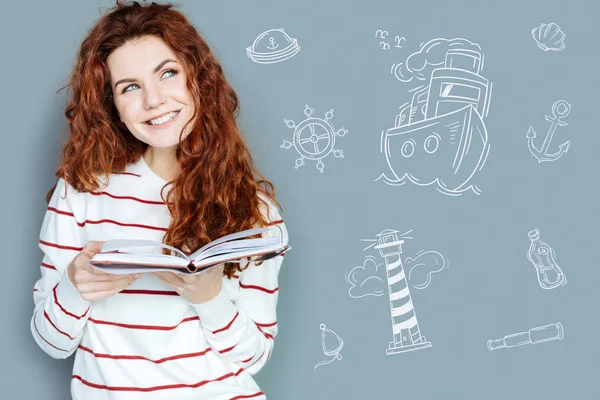 Jovencita feliz sonriendo y disfrutando de un nuevo libro —  Fotos de Stock