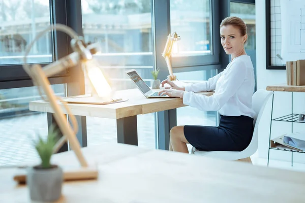 Upptagen kvinna sitter på hennes arbetsplats — Stockfoto