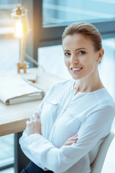 Vrolijke vrouwelijke persoon wordt op het werk — Stockfoto