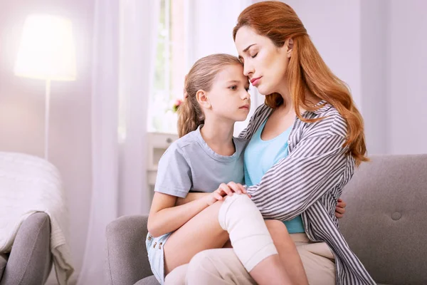 Piacevole donna dai capelli rossi che abbraccia il suo bambino — Foto Stock