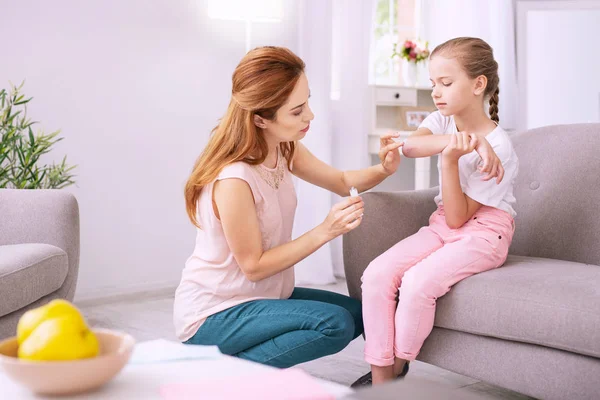 Agradable buena mujer ayudando a su hija — Foto de Stock