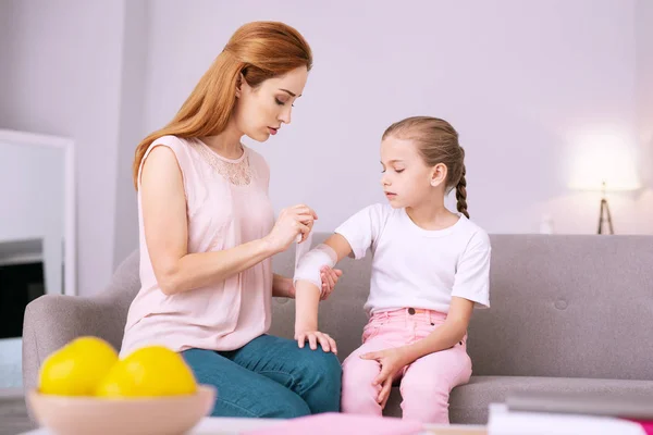 Serieuze jonge vrouw die haar dochters hand — Stockfoto