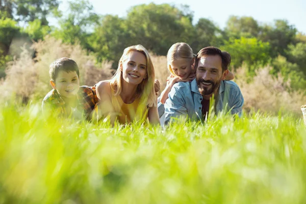 Família inspirada deitada na grama — Fotografia de Stock