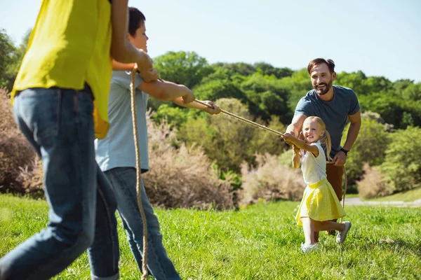 Família encantada jogando um jogo no parque — Fotografia de Stock