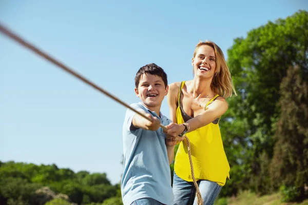 Joyful family pulling a rope in the park — Stock Photo, Image