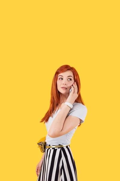 Attraktive junge Frau, die sich ein Telefon ans Ohr hält — Stockfoto