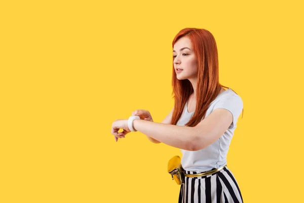 Belle femme aux cheveux rouges utilisant une smartwatch — Photo